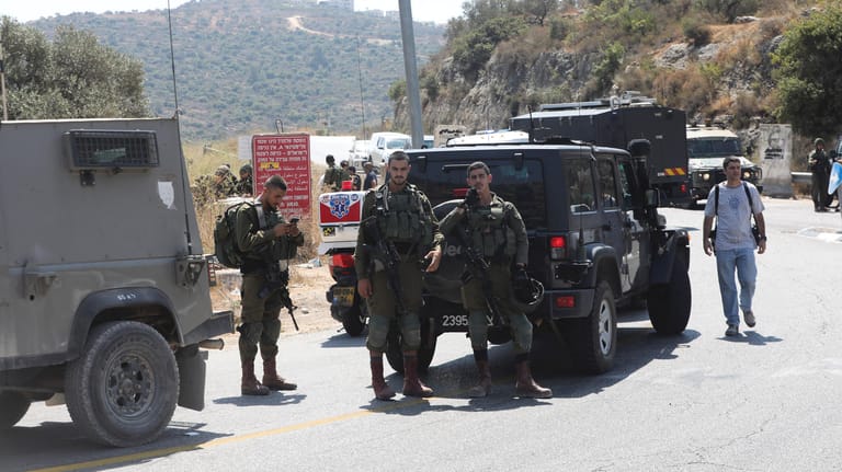 Nach dem Anschlag in Dolev errichten israelische Soldaten Straßensperren in der Umgebung.