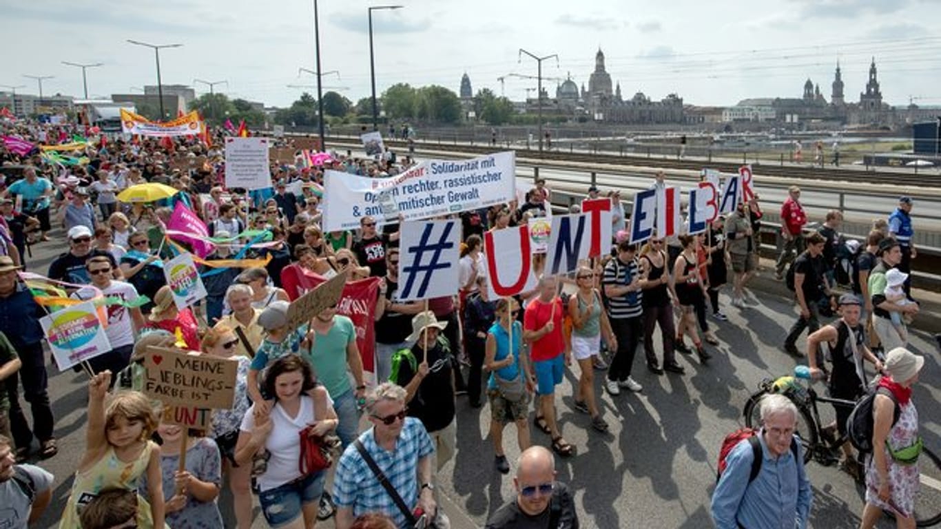 Vor der historischen Altstadtkulisse gehen Tausende Teilnehmer der Demonstration des Bündnisses #Unteilbar über die Carolabrücke in Dresden.