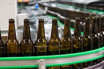 Gewaschene Bierflaschen auf Fließband: Das Pfand für Bierflaschen ist zu billig, meinen die Brauer und fordern einen Aufschlag.