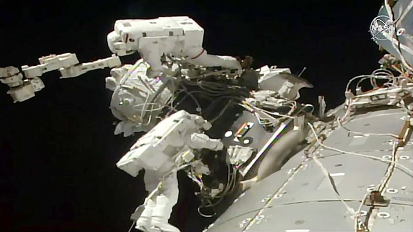 Astronautenbei der Installation eines einen Adapters an der ISS.