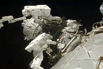 Astronautenbei der Installation eines einen Adapters an der ISS.
