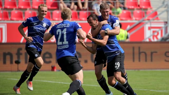 Die Spieler von Arminia Bielefeld freuen sich nach dem Sieg in Regenburg über die Tabellenführung.