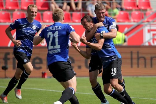 Die Spieler von Arminia Bielefeld freuen sich nach dem Sieg in Regenburg über die Tabellenführung.