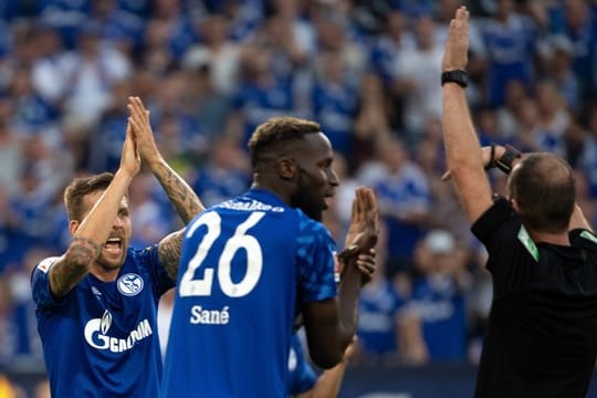 Schalkes Sane (M) und Burgstaller (l) beschweren sich bei Schiedsrichter Fritz über ein nicht gegebenes Handspiel.