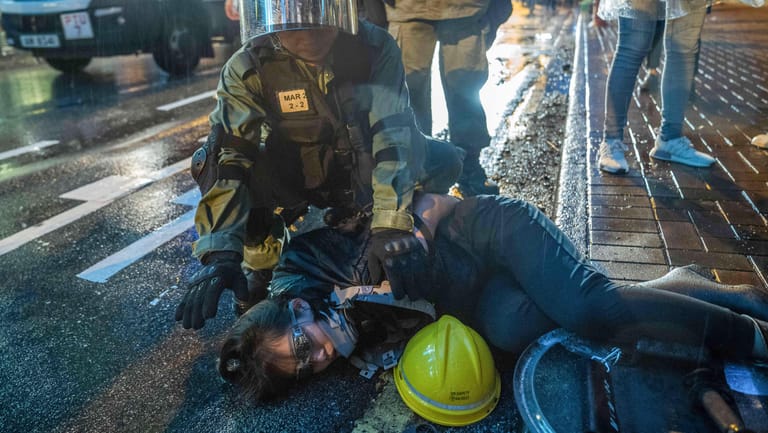 Hongkong: Eine Demonstrantin wird während eines Protests von einem Polizisten festgehalten. Bei Protesten in Hongkong ist es erneut zu schweren Zusammenstößen zwischen Polizei und Demonstranten gekommen.
