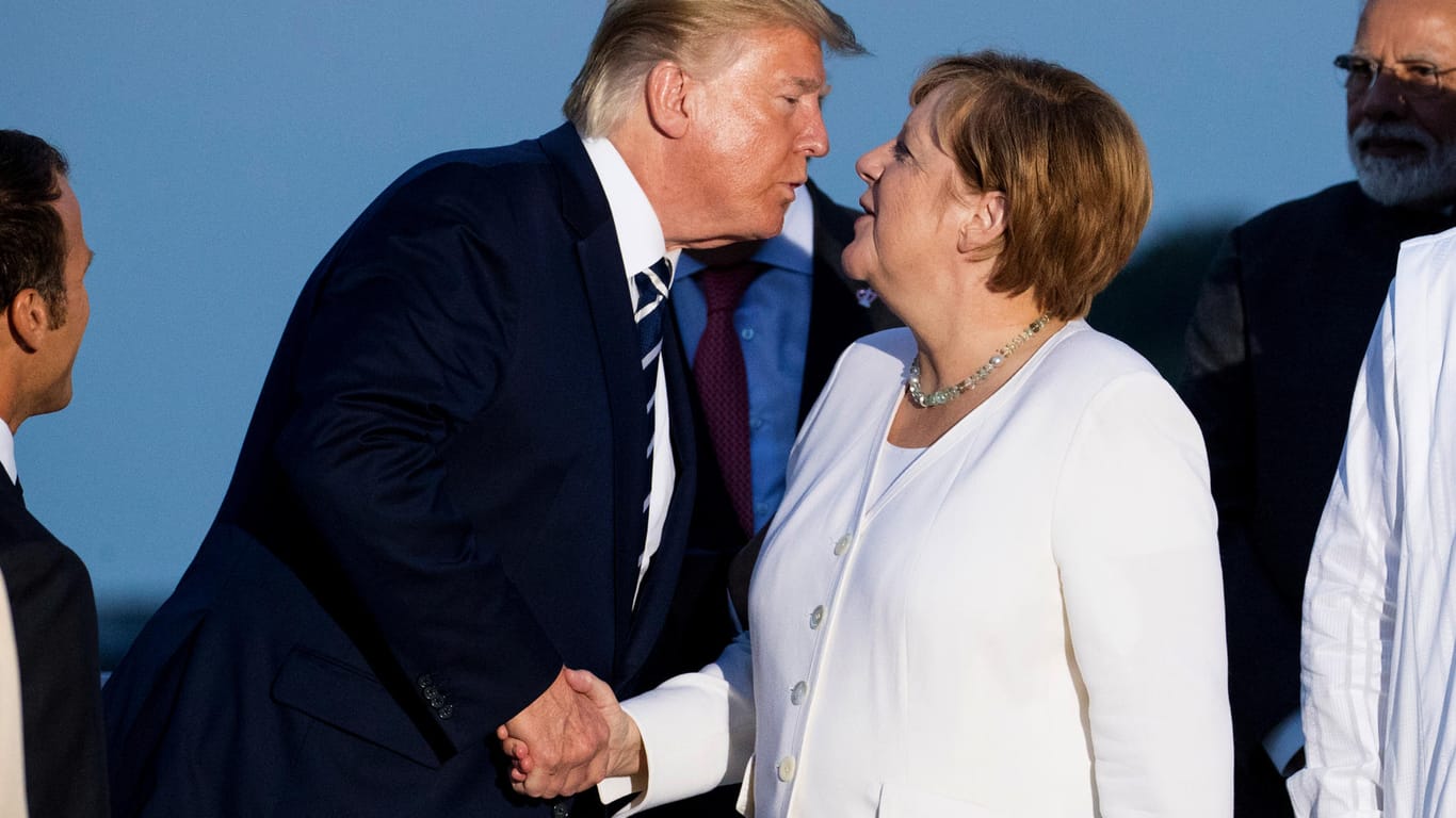Biarritz: Donald Trump küsst Angela Merkel zur Begrüßung beim gemeinsamen Familienfoto im Rahmen des G7-Gipfels.