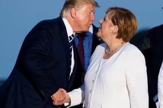 Biarritz: Donald Trump küsst Angela Merkel zur Begrüßung beim gemeinsamen Familienfoto im Rahmen des G7-Gipfels.