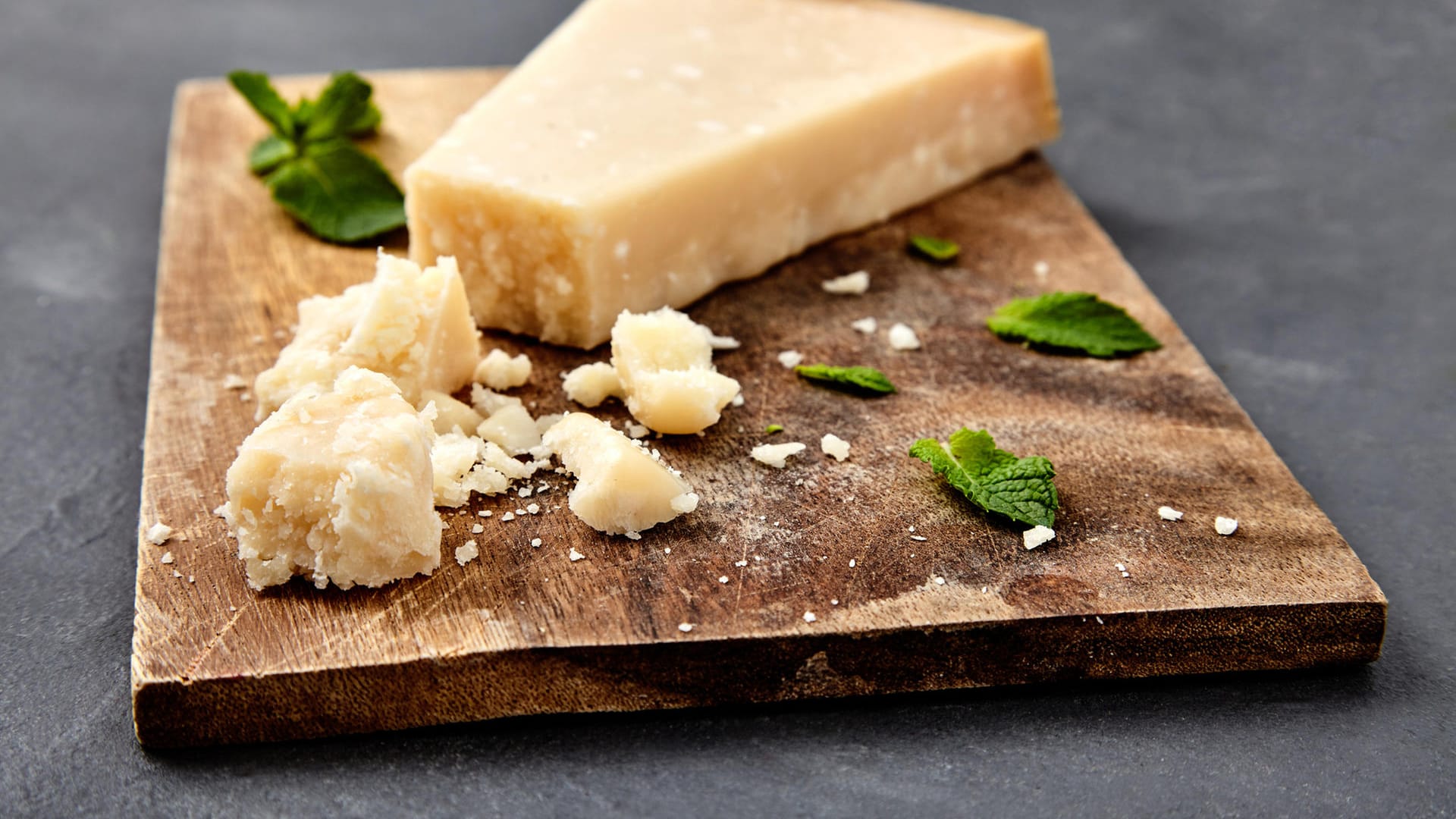 Parmesan angerichtet auf einem Holzbrett: Damit ein Käse sich "Parmigiano Reggiano" nennen darf, muss er laut EU-Verordnungen eine Reihe von Auflagen erfüllen.