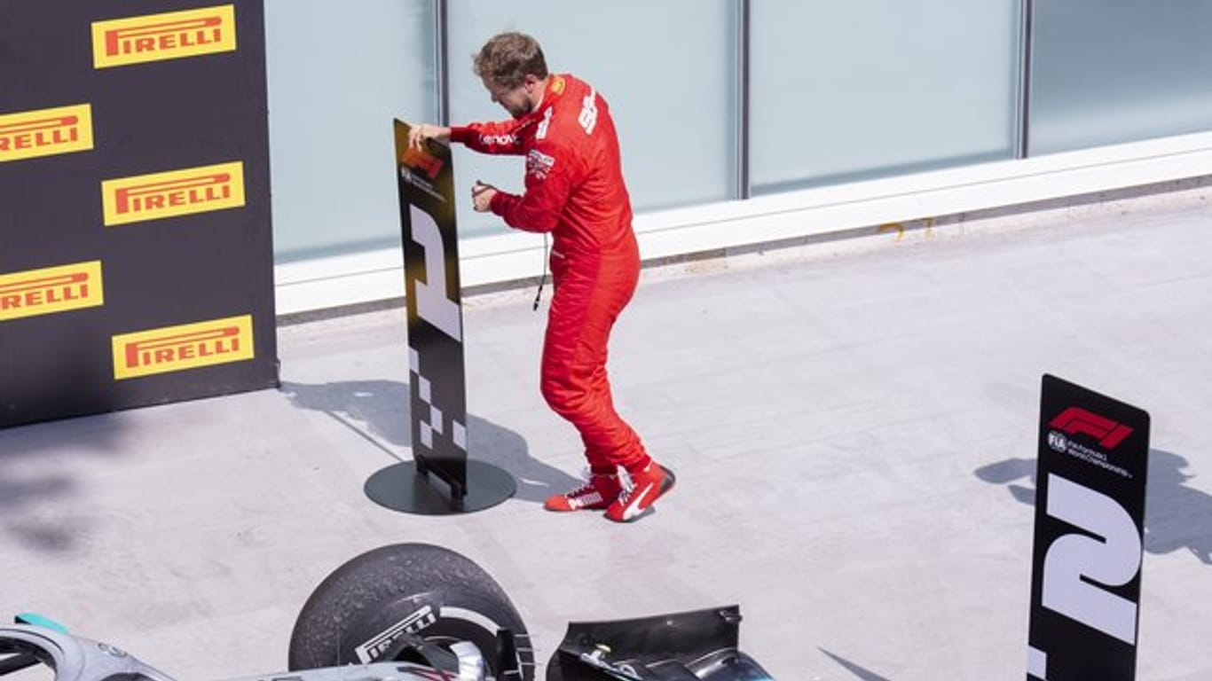 Sebastian Vettel vertauscht in Kanada im Parc Fermé die Nummerntafeln für Platz eins und zwei.