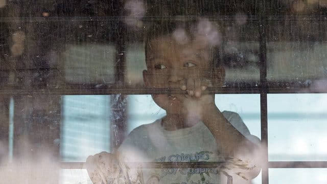 Ein Kleinkind aus einer Familie illegaler Migranten an der Grenze zwischen Mexiko und den USA hinter dem Fenster eines Busses. Ein Kleinkind aus einer Familie illegaler Migranten an der Grenze zwischen Mexiko und den USA hinter dem Fenster eines Busses.