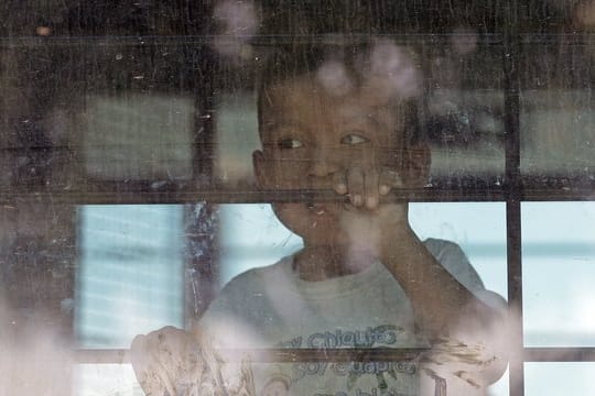Ein Kleinkind aus einer Familie illegaler Migranten an der Grenze zwischen Mexiko und den USA hinter dem Fenster eines Busses.