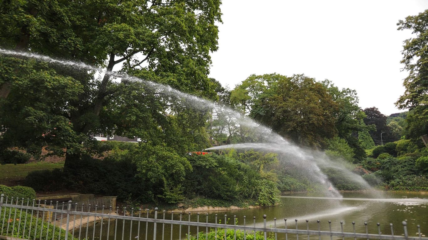 Wasser aus Feuerwehrautos spritzt in einen Teich: In Wuppertal musste ein Teich wegen Wassermangel von der Feuerwehr aufgefüllt werden.