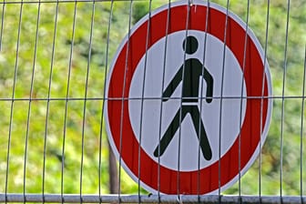 Ein Hinweisschild hinter einem Bauzaun: Fußgänger können einen Teil des Gehwegs in der Großen Bleiche in Mainz für einen Monat lang nicht nutzen.