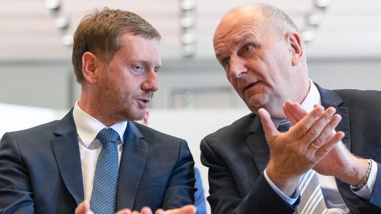 Michael Kretschmer (CDU), Ministerpräsident von Sachsen, und Dietmar Woidke (SPD), Ministerpräsident von Brandenburg, unterhalten sich: Die Umfragewerte von beiden steigen wenige Wochen vor der Wahl wieder.