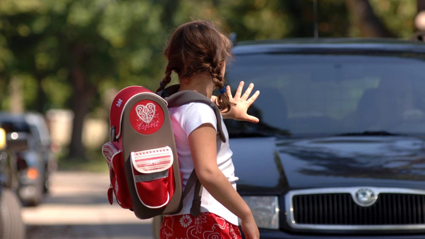 Ein Mädchen stoppt ein Auto: In Mainz bringen viele Eltern ihre Kinder mit dem Wagen zur Schule.