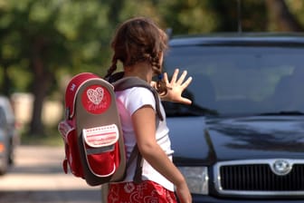 Ein Mädchen stoppt ein Auto: In Mainz bringen viele Eltern ihre Kinder mit dem Wagen zur Schule.