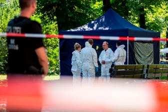 Beamte der Spurensicherung an einem Faltpavillon am Tatort: Der Verdächtige schweigt zu der Tat.