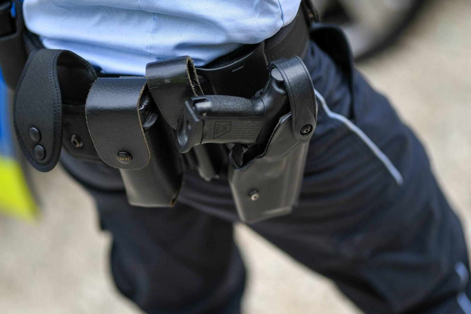 Ein Polizist mit Dienstpistole (Symbolbild): Kam es beim Tod des Polizisten zu einer Verwechslung der Waffen?