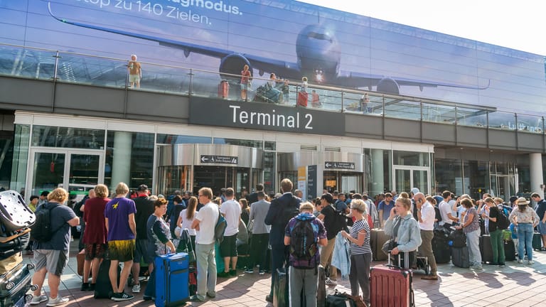 Fluggäste stehen vor dem verschlossenen Eingang zum Terminal 2: Teile des Münchner Flughafens sind geräumt worden.
