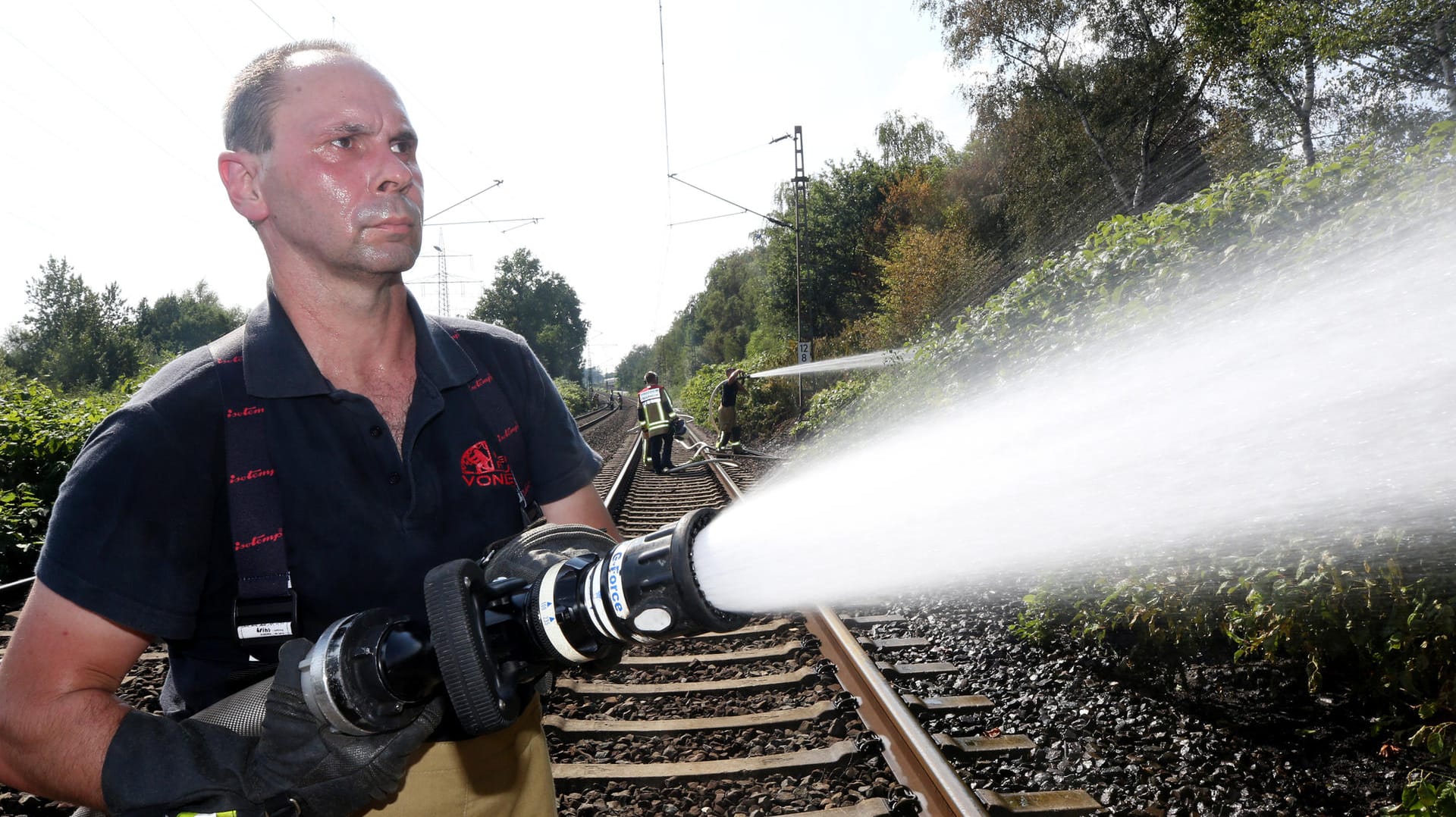 Ein Feuerwehrmann im Einsatz bei Bottrop: Tausende Quadratmeter an Bahndamm in Flammen. Ein Feuerwehrmann im Einsatz bei Bottrop: Tausende Quadratmeter an Bahndamm in Flammen.
