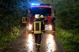 Schleswig-Holstein, Aukrug-Homfeld: Männer der Freiwilligen Feuerwehr sind nach einem heftigen Gewitterregen im Einsatz.