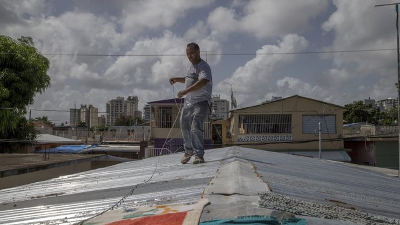 Ein Mann befestigt in San Juan sein Dach vor der erwarteten Ankunft des Tropensturms "Dorian".