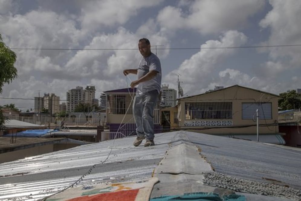 Ein Mann befestigt in San Juan sein Dach vor der erwarteten Ankunft des Tropensturms "Dorian".