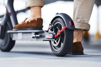 Ein Mann steht auf einem E-Scooter: In Mainz musste ein Rollerfahrer nach einer Polizeikontrolle zu Fuß weitergehen.