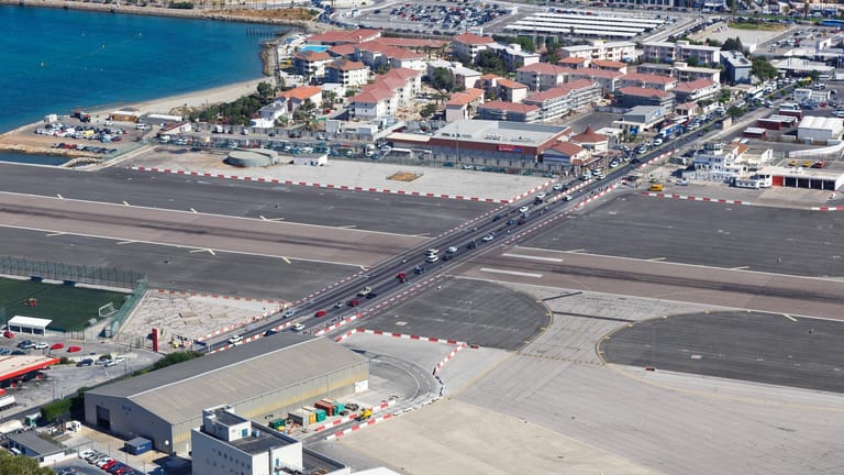 Gibraltar Airport, Gibraltar: Hier wird der Verkehr auf der Hauptstraße gelegentlich durch startende und landende Flugzeuge unterbrochen.