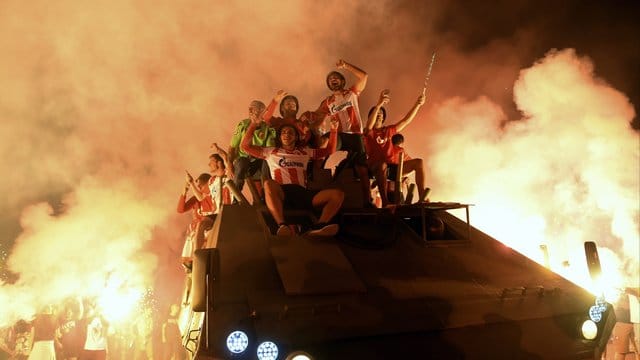 Spieler und Fans von Roter Stern Belgrad feiern mit Fackeln auf einem offenen Panzerfahrzeug den Einzug in die Gruppenphase der Champions League. Spieler und Fans von Roter Stern Belgrad feiern mit Fackeln auf einem offenen Panzerfahrzeug den Einzug in die Gruppenphase der Champions League.