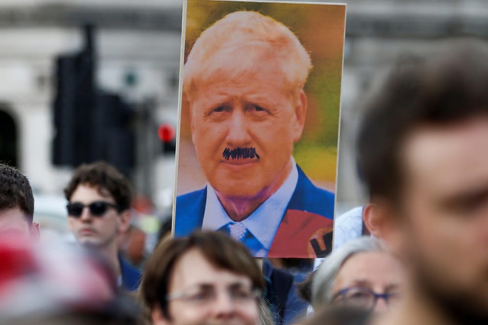 Boris Johnson mit Hitler-Bart, Protest in London: "Was in Großbritannien passiert ist langsamer und schlimmer: die Erosion seiner Fundamente."