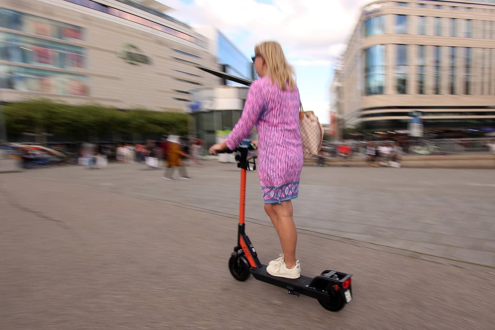 Frau fährt mit einem E-Scooter in Frankfurt: Bald soll es auch Rollerverleihe in Karlsruhe geben.