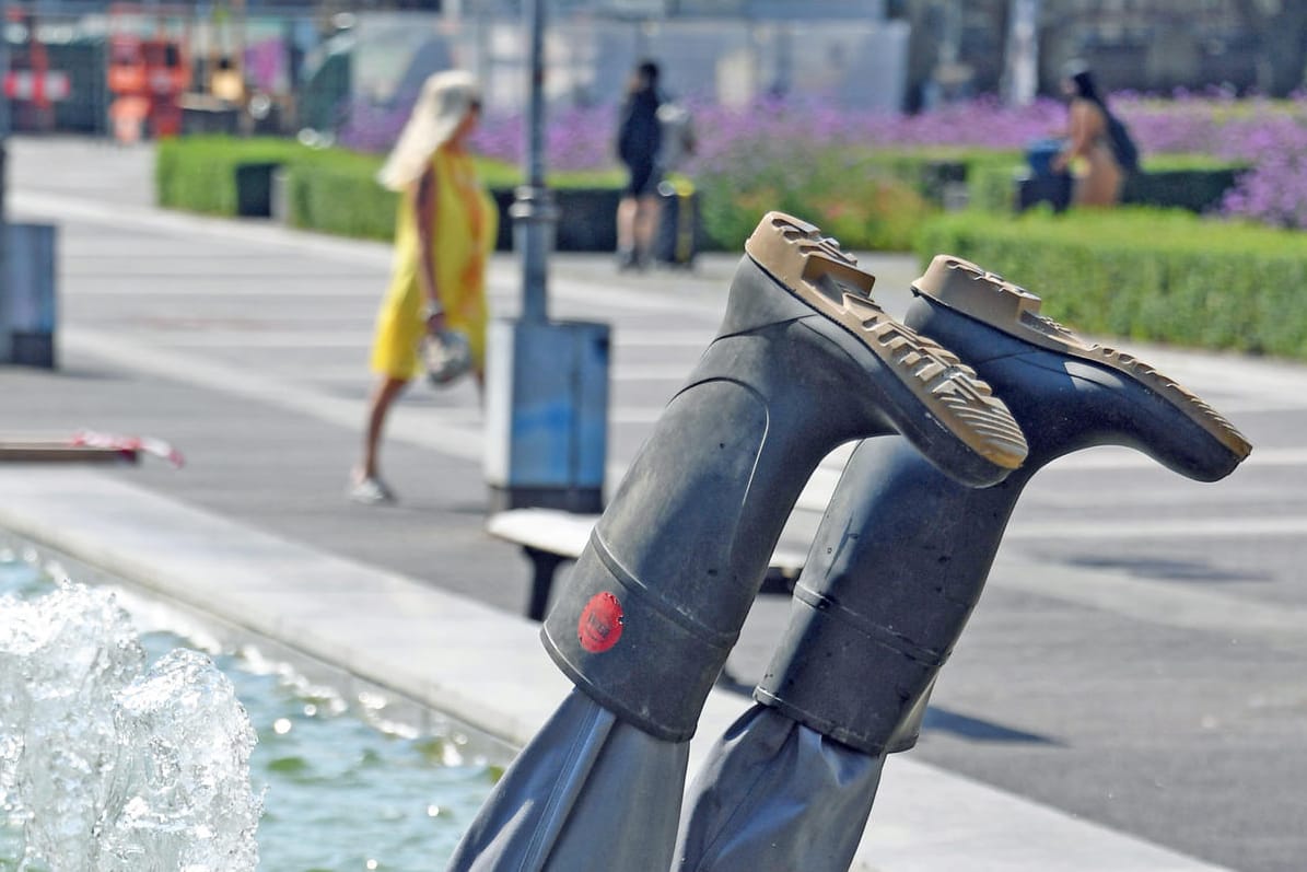 Aus einem Brunnen ragen zwei Beine mit Gummistiefeln hervor: Die Installation eines Karlsruher Künstlerpaares wurde aus dem Wasser entfernt.