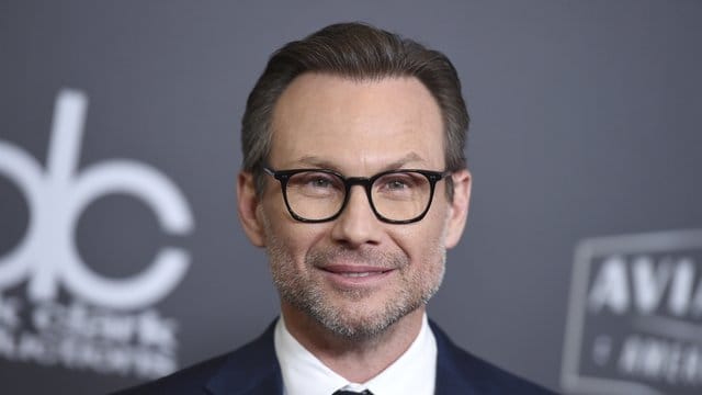 Christian Slater freut sich über ein Mädchen.