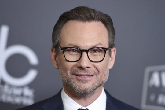 Christian Slater freut sich über ein Mädchen.