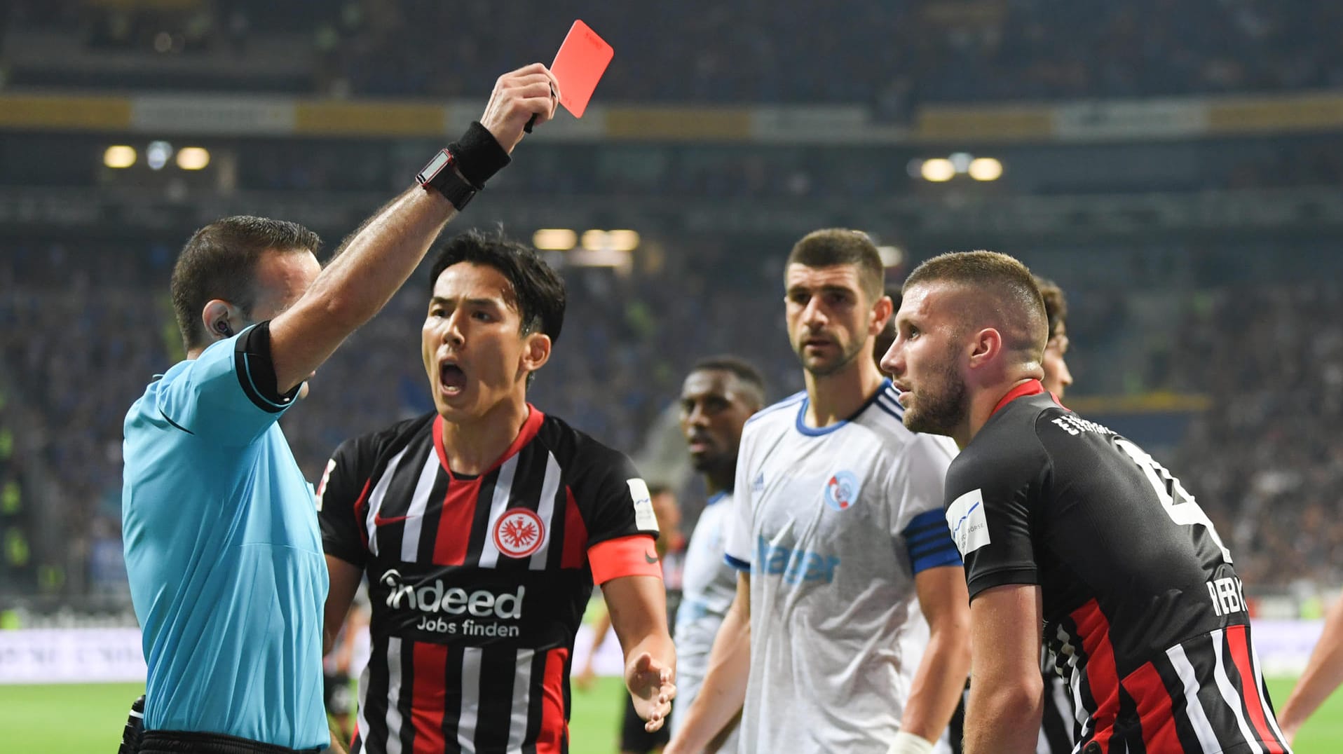 Schiedsrichter Orel Grinfeld (l.) zückt die Rote Karte, Makoto Hasebe und Ante Rebic können es kaum glauben.