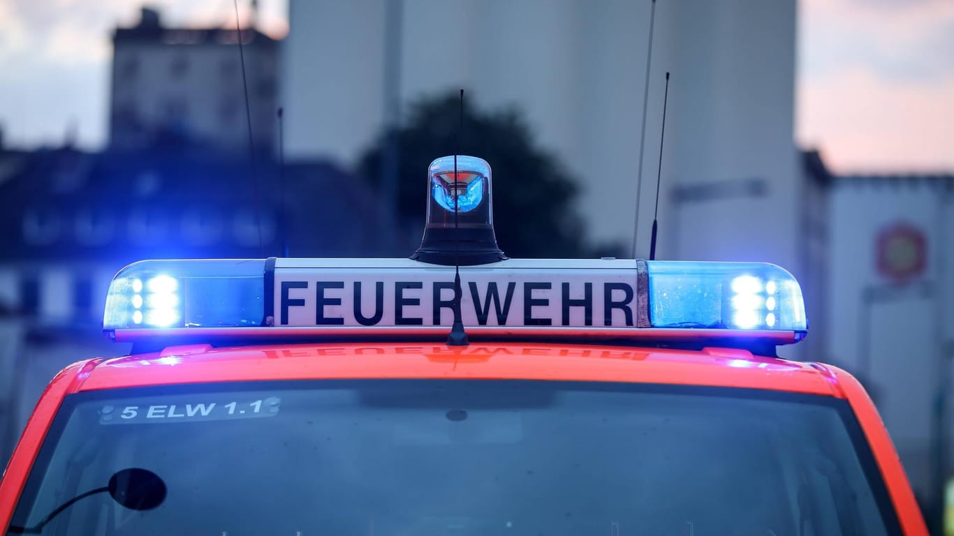 Feuerwehrwagen mit Blaulicht: In Köln-Porz brannte am Donnerstagabend ein Mehrfamilienhaus.