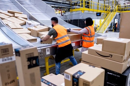 Mitarbeiter des Paketversenders Amazon sortieren Pakete im Sortierzentrum in Garbsen.
