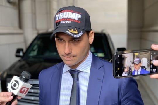 Eduardo Bolsonaro, Abgeordneter und Sohn des Präsidenten, spricht mit einer Trump-Mütze auf dem Kopf zu Journalisten.