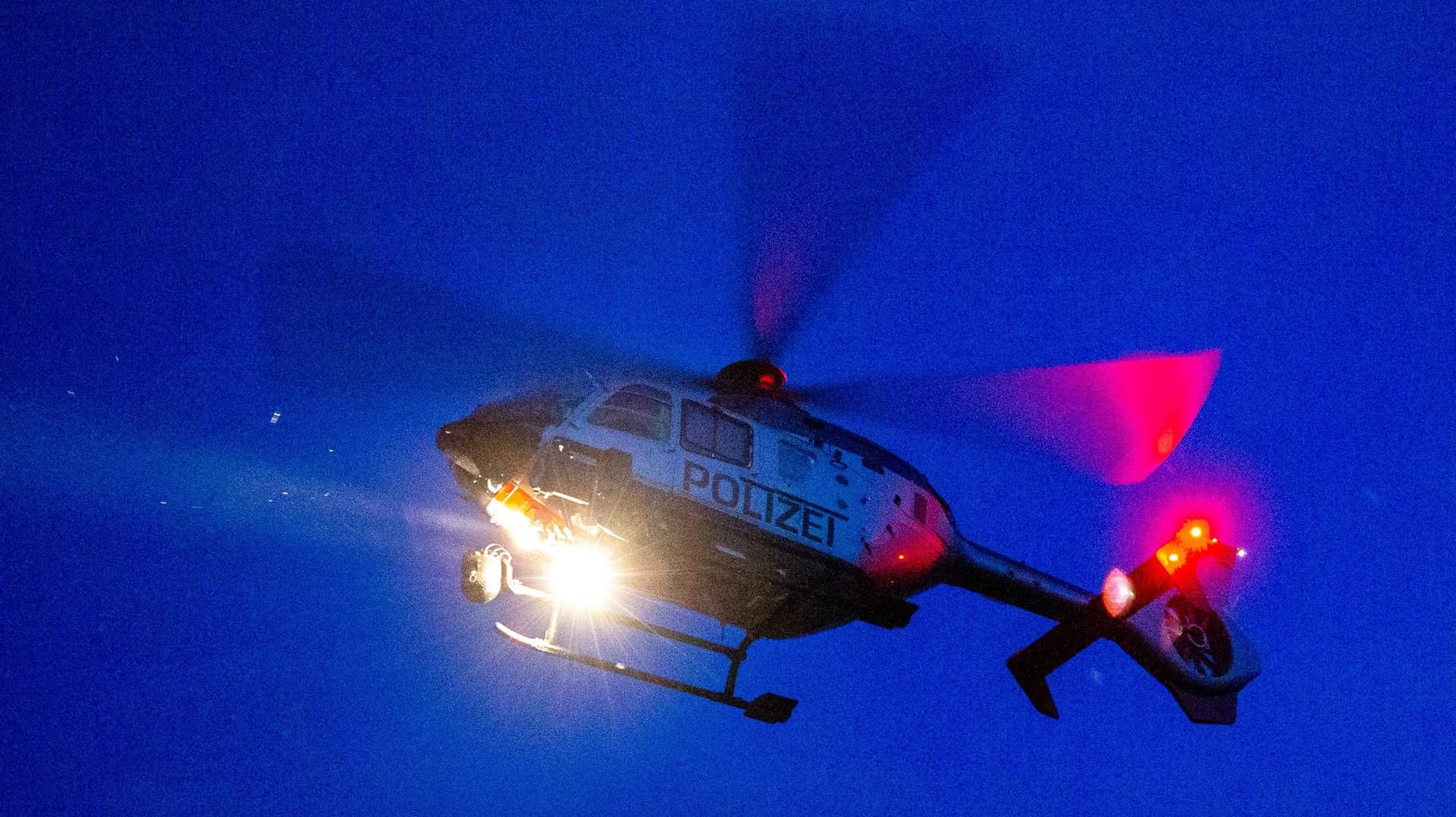 Ein Polizeihubschrauber fliegt in der Nacht: In Essen suchte die Polizei mit einem Hubschrauber nach einer vermissten 85-Jährigen.