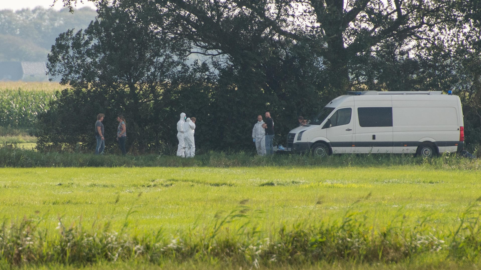 Stadum in Schleswig-Holstein: Ermittler in weißen Schutzanzügen stehen während eines Polizeieinsatzes im Zusammenhang mit der vermissten 23-jährigen Nathalie M. aus Nordfriesland neben einem Polizeifahrzeug.