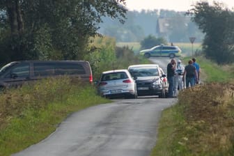 Mitarbeiter der Spurensicherung stehen auf einem Weg in der Nähe des Resthofs des Tatverdächtigen in Nordfriesland.
