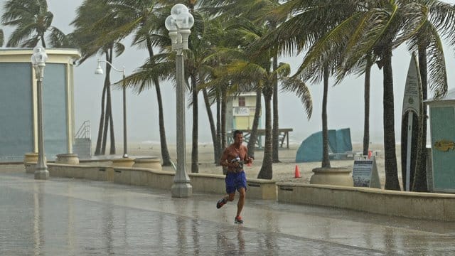 Ein Mann rennt am Hollywood Beach durch den Regen.