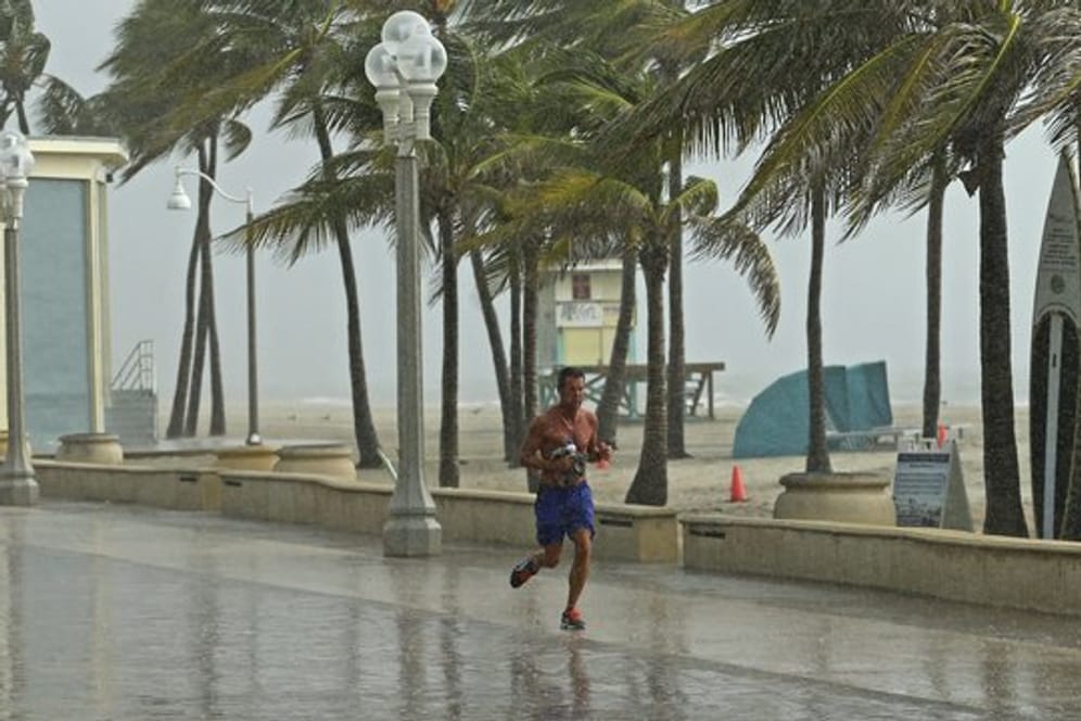 Ein Mann rennt am Hollywood Beach durch den Regen.
