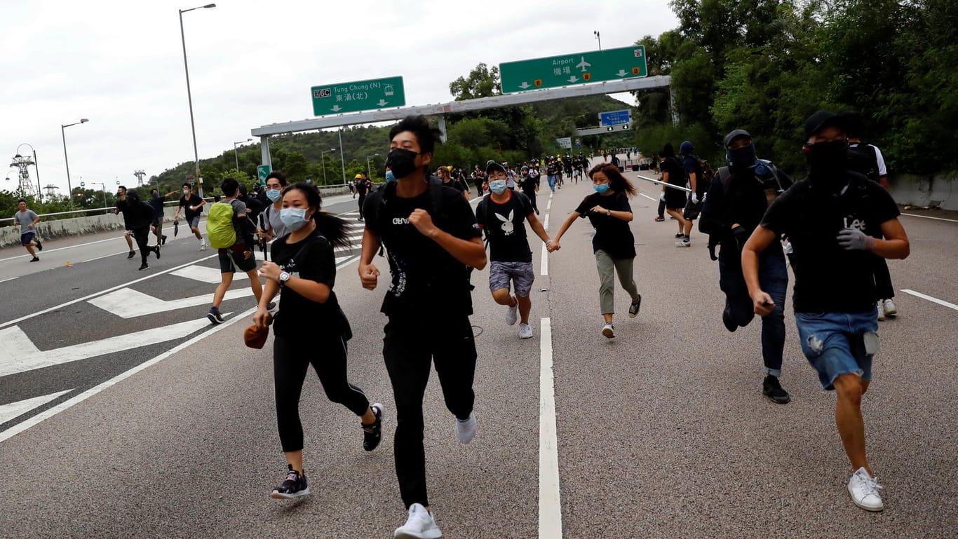 Demonstranten laufen vor der Polizei weg: Am Sonntag versuchten Tausende, den Flughafen in Hongkong lahmzulegen.
