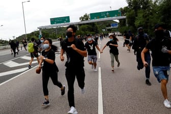 Demonstranten laufen vor der Polizei weg: Am Sonntag versuchten Tausende, den Flughafen in Hongkong lahmzulegen.