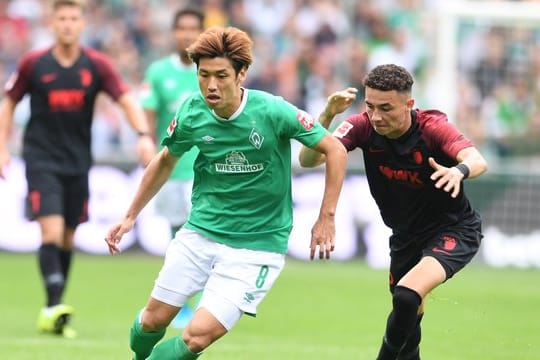 Werders Yuya Osako (l) setzt sich gegen Augsburgs Ruben Vargas durch.