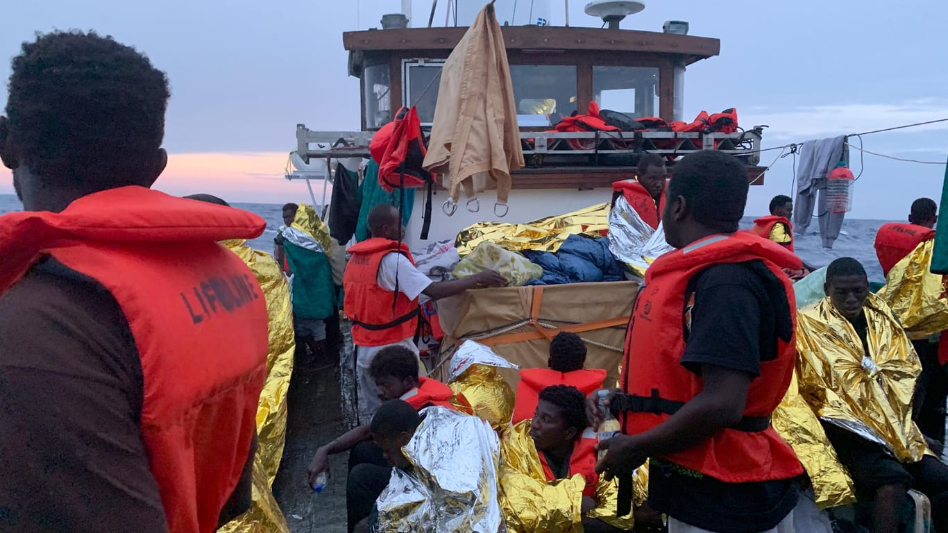 Situation auf dem Rettungsschiff "Eleonore": Nach einem Gewitter mit schweren Regenfällen schützen sich die rund 100 Migranten an Deck mit Rettungsdecken.