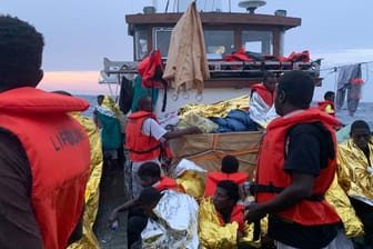 Situation auf dem Rettungsschiff "Eleonore": Nach einem Gewitter mit schweren Regenfällen schützen sich die rund 100 Migranten an Deck mit Rettungsdecken.