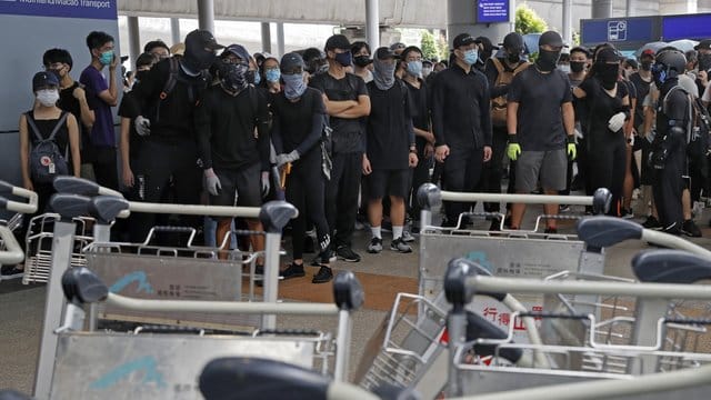 Demonstranten blockieren eine Straße vor dem Hongkonger Flughafen.